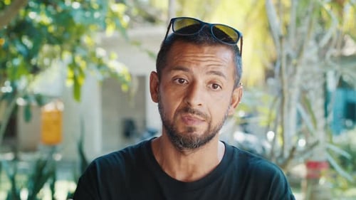 Portrait of the Hispanic Young Man Talking and During Interview with Naturally Blurred Background