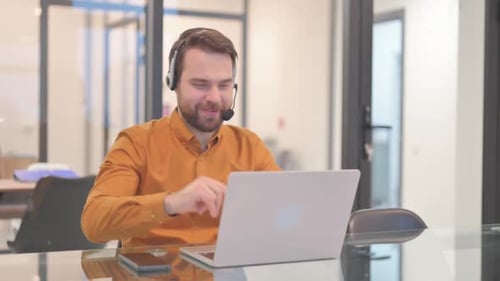 Young Adult Customer Service Representative Working On Laptop