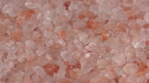 Pink himalayan salt or rock salt rotating macro background low light. Trace minerals salt used