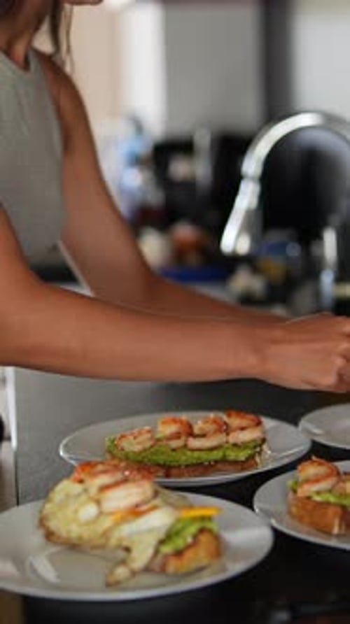 Woman Assembling Healthy Shrimp and Avocado Toast
