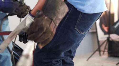 View Of Manual Workers At Work Fabricating Metal Structure. close up