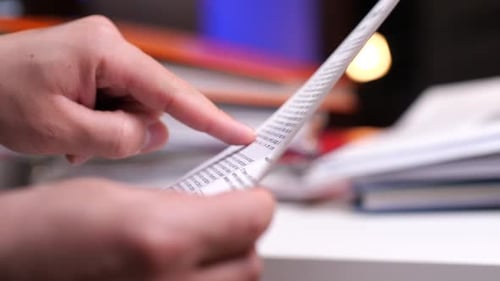 Hands Holding and Reading Paper Document