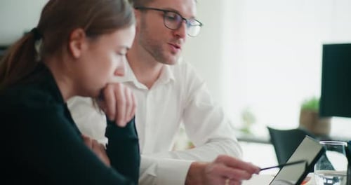 Business Team Discussing Data on Tablet in Office