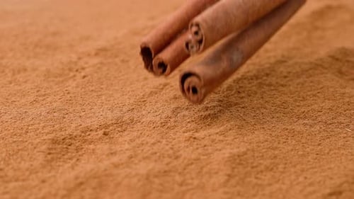 Vue en gros plan en studio d'un fond d'épices avec de la poudre de cannelle séchée brune avec quelques fractions