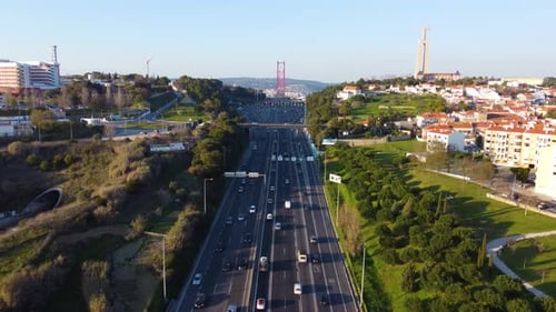 Drone shot flying backwards over a highway with Lisbon in the background.