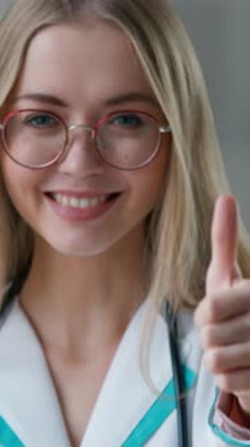 Portrait Caucasian Doctor Showing Thumb Up Like Gesture Smiling in Clinic Looking at Camera Happy