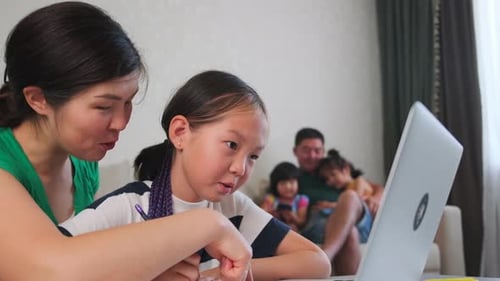 Woman Helping Child With Homework at Home