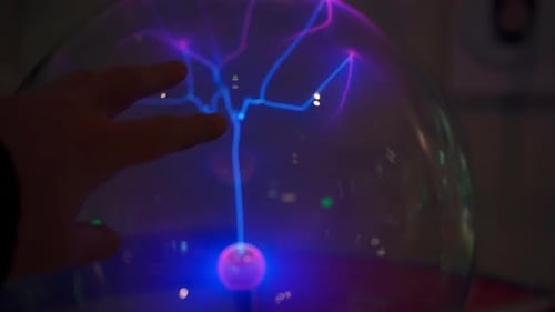 Hand Touching Plasma Ball with Smooth Magenta Blue Flames