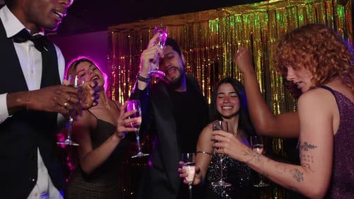 Amigos brindando taças de champanhe na festa de Ano Novo em câmera lenta