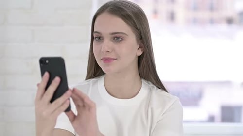 Young Woman Using a Mobile Phone Indoors