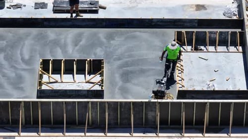 Aerial of Worker Finishing Concrete on Construction Site
