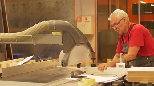 Man uses saw in woodworking factory, cuts wood