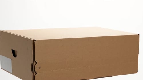 A cardboard box with a white label rotates on a white background.