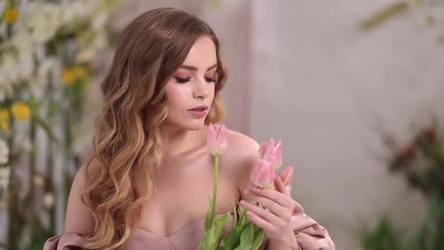 Glamorous Woman Holds Pink Tulips in Bright Studio