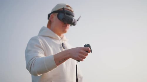 Unmanned aircraft pilot use goggles and rc motion remote to fly FPV drone