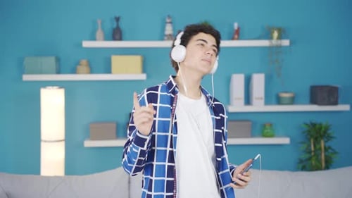 Teen Boy Dancing at Home with Headphones and Phone