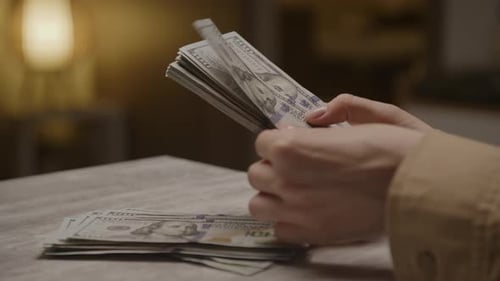 Hands Counting Stacks of One Hundred Dollar Bills