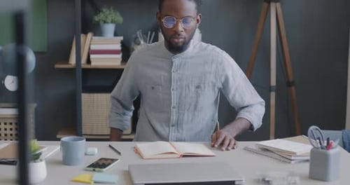 Young Adult Opens Laptop in Home Office