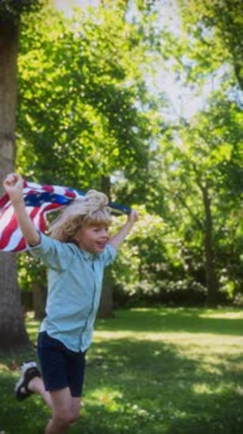 Exuberant Boy Runs with American Flag in Sunny Park