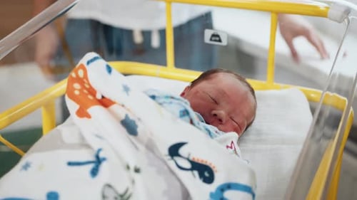 Очаровательный кавказский новорожденный ребенок лежит на больничной койке в детском саду