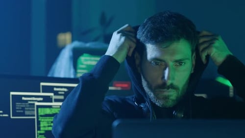 A Focused Hacker Engaged in Work Late at Night in a Dimly Lit Environment Concentrating