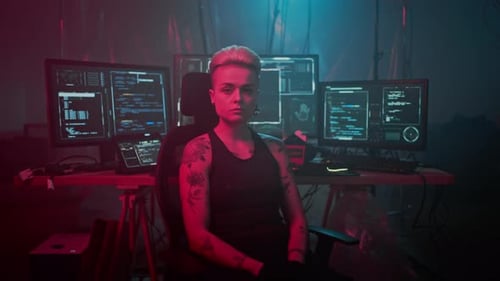 Hacker Turns Around on Armchair Against Different Monitors