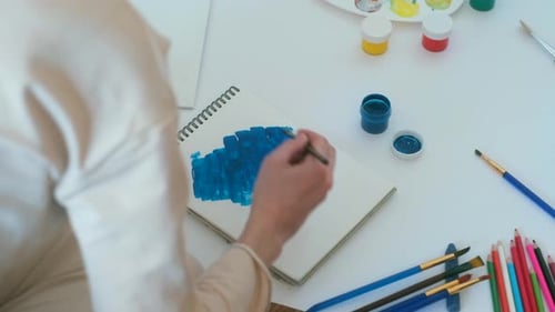 Artist Painting Blue Abstract on Sketchbook