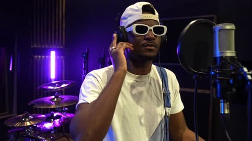 Young african american singer recording music in studio