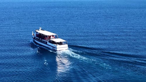 Weißes Schiff auf blauem Wasser mit Touristen, die die Fahrt genießen