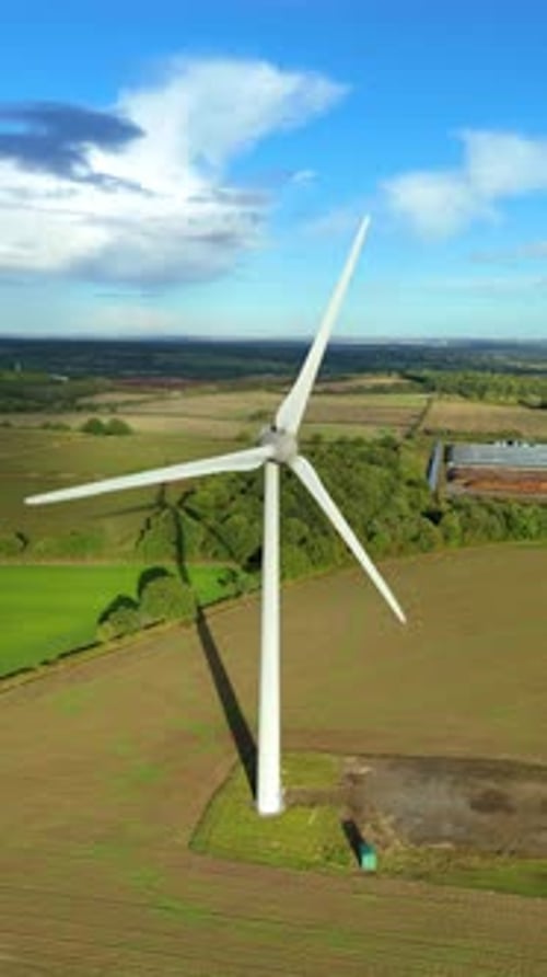 Aerial drone view of wind turbines in green farmland with rolling hills and valleys near Leicester