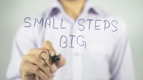 Writing "Small Steps Big Changes" On Glass