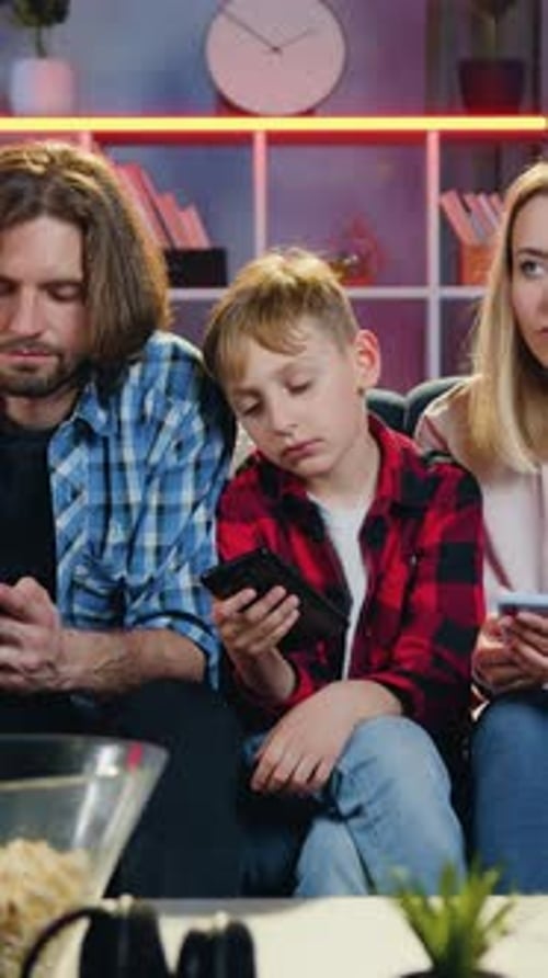Family using smartphones in living room at home