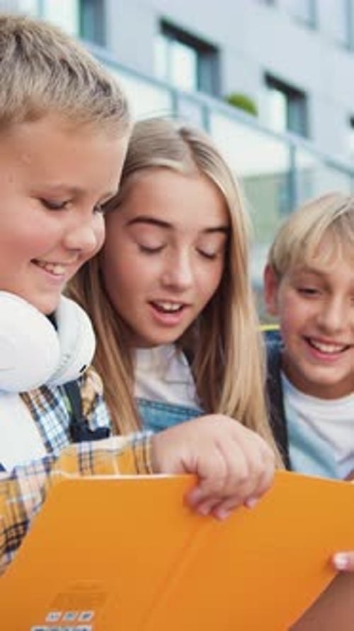 Group of Elementary School Children Writing in Their Copybooks Having an Outdoor Classwhile Sitting