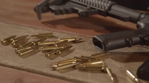 Dolly out over ammunition scattered in front of loaded AR-15