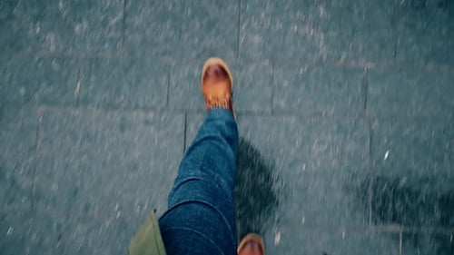 Lederstiefel, die auf nassem Stadtpflaster laufen