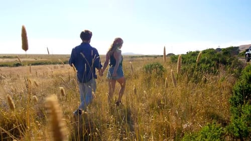 Couple Walking Together in Field of Tall Grass