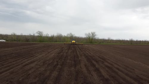 Blue tractor OA working on the field in Ukraine