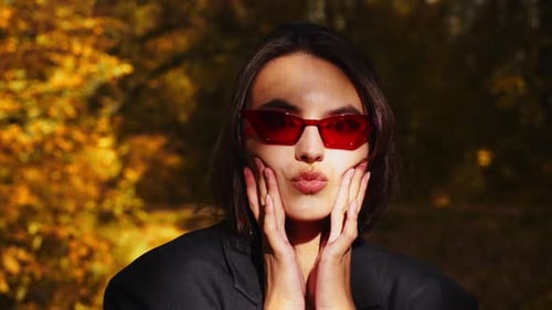 Stylish Woman with Red Sunglasses in Autumn Park