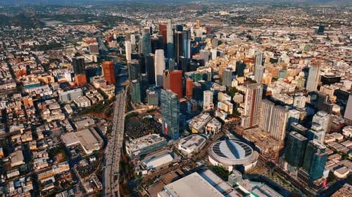 Wide-lane highway passing Los Angeles downtown is full of cars.