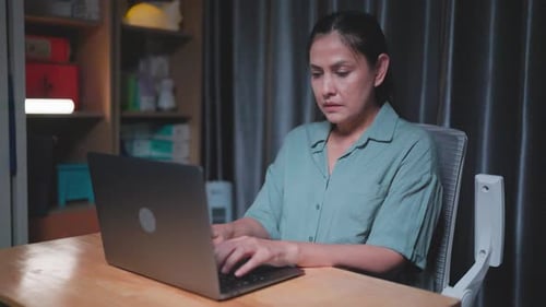 Stressed woman working late at night in the office hands on head feeling headache, Tired woman looki