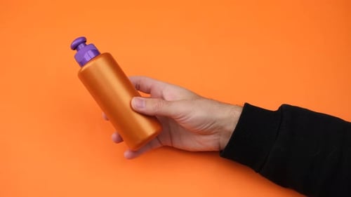 Person Hand Holding a Sunscreen Cream