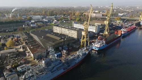 Vue aérienne du chantier naval avec grues et navires amarrés dans un port urbain