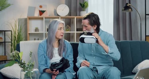 Senior Couple Experiencing Virtual Reality Headsets at Home
