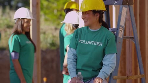 Smiling Volunteers Collaborate on House Construction Project