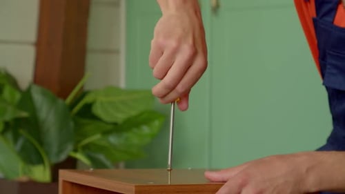 Close Up of Man Assembling Furniture with Screwdriver