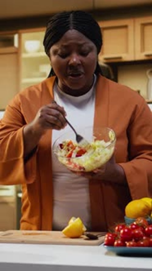 Woman Enjoys Salad in Bright Kitchen
