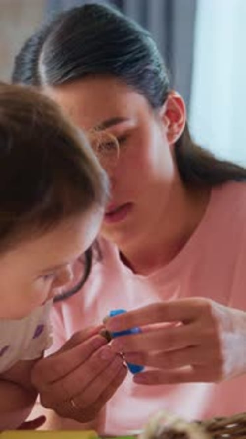 Child and Woman Playfully Molding Colorful Clay Indoors