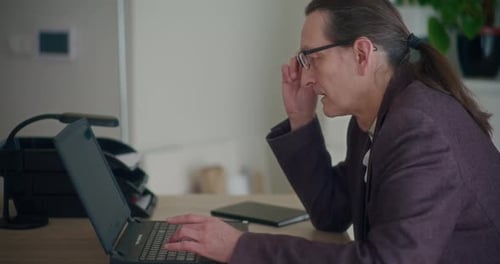 Man with Glasses Working at a Laptop