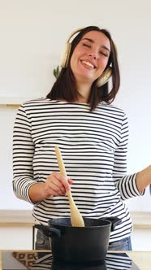 Woman Cooking and Dancing to Music at Home