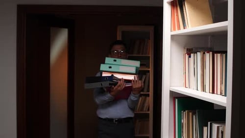 Office Worker Carrying Stack of Binders in Library or Archive